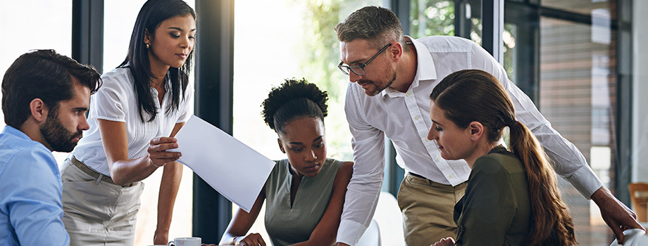 A group of colleagues discuss capacity planning at a conference table.