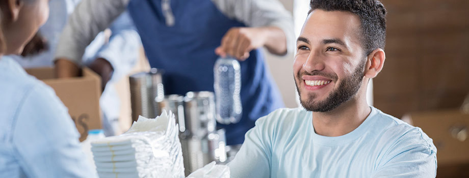 Smiling young man hands supplies to a woman